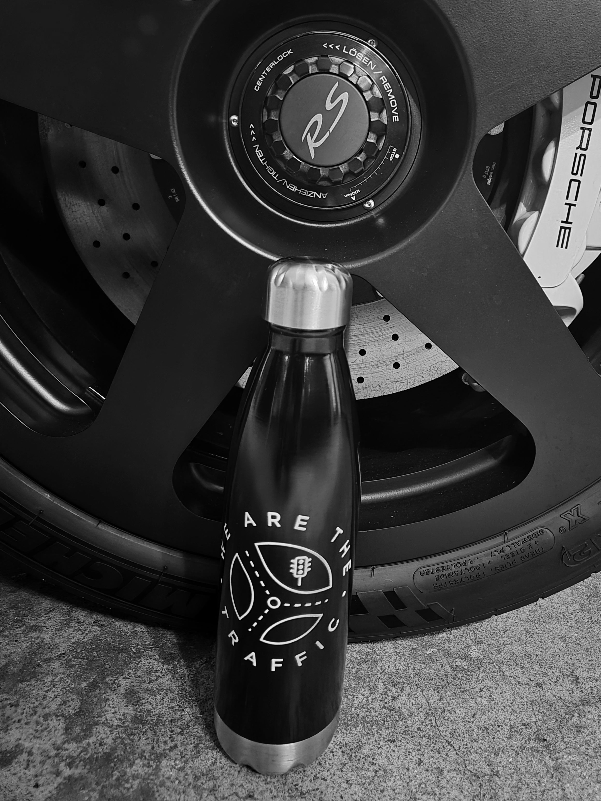 We are the traffic logo water bottle next to a porsche tire