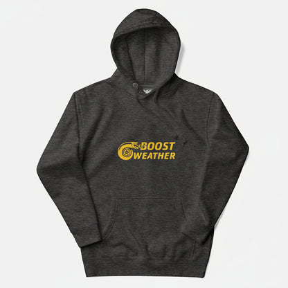 Flat lay of a hoodie in charcoal heather gray with a gold design featuring the phrase Boost Weather and a tire with fire design next to it.