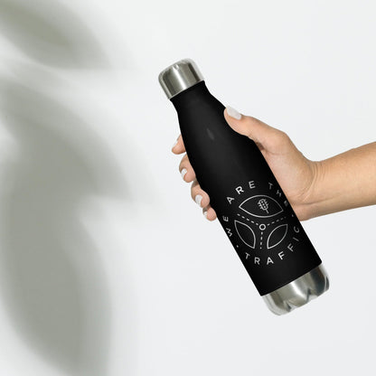 Black and stainless steel We Are The Traffic water bottle being held.