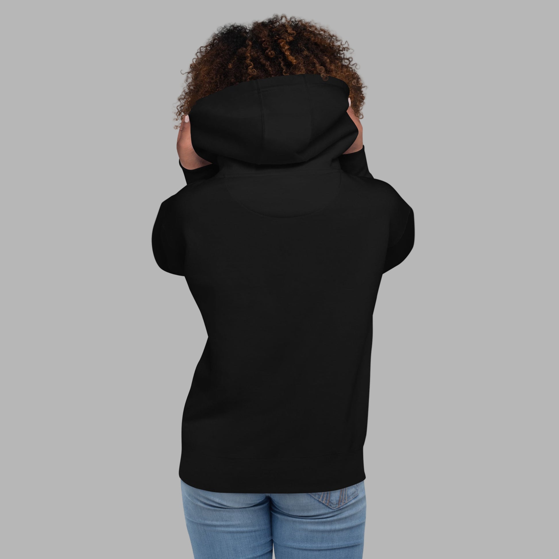 Person wearing a black hoodie on a gray background