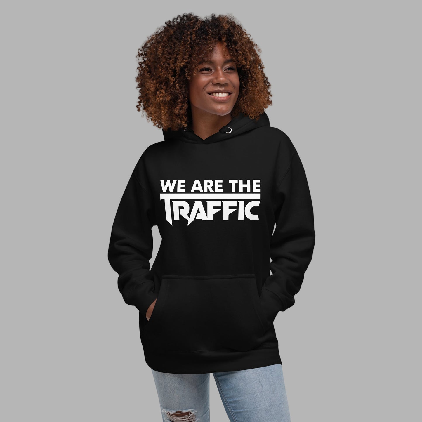Person wearing a black hoodie with 'WE ARE THE TRAFFIC' text on a gray background